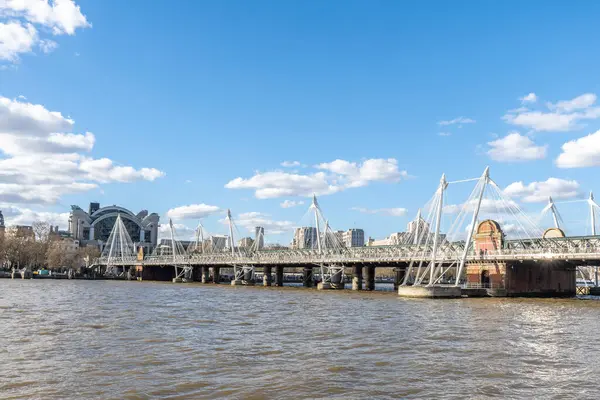 Hungerford nehri üzerindeki demiryolu köprüsünü çevreleyen modern yaya köprüsü. Arka planda istasyon, Londra, İngiltere...