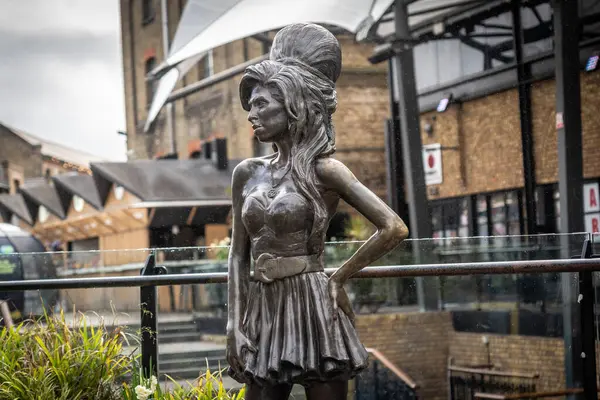 Eski şarkıcı Amy Winehouse 'un bronz heykeli. Ahır pazarında gururla duruyor. Camden Town, Londra.