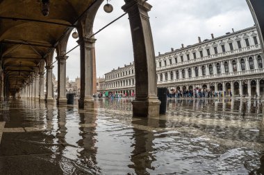 Venedik, İtalya 'daki Piazza San Marco' yu ziyaret eden turistler, yağmura rağmen kemerlerin altında sel baskınına yol açtılar.
