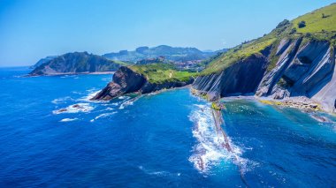 Güneşli bir yaz günü, Zumaia, Gipuzkoa 'da, Cantabrian Denizi' nin derin mavi sularıyla buluşan eşsiz uçurumların nefes kesici hava manzarası.