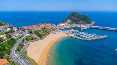 Getaria 'nın havadan görünüşü, Bask Bölgesi' nde büyüleyici bir kıyı kasabası, İspanya, pitoresk limanı, kumlu sahili ve güneşli bir yaz gününde ikonik San Anton Dağı.