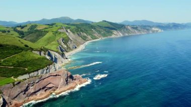 Zumaia 'nın sineklik kıyı şeridinin nefes kesen hava perspektifi eşsiz jeolojik oluşumlarını ve canlı yaz renklerini gözler önüne seriyor.