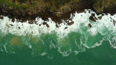 Yazın Bask ülkesinde, Zarautz, Gipuzkoa 'nın kayalık sahil şeridine çarpan dalgaların hava görüntüsü
