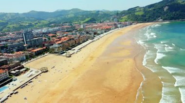 Zarautz 'un altın plaj buluşmasını gösteren hava perspektifi, Bask ülkesinin yeşil tepelerinin zeminine kurulmuş turkuaz Cantabrian Denizi' ni gözler önüne seriyor.