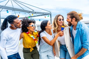 Beş neşeli arkadaş karaoke yapıyor, mikrofon tutuyor ve yaz boyunca çatıda eğleniyorlar.