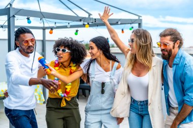 Bir grup farklı arkadaş çatıda kutlama yapıyor, karaoke söylüyor, neşeyle dans ediyor ve birlikte coşkulu bir yaz partisinin tadını çıkarıyorlar.