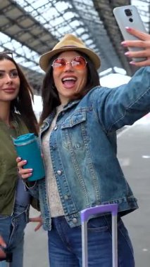 Mutlu çoklu etnik arkadaşlar selfie çekiyor ve tren istasyonunda birlikte eğleniyorlar. Yolculukları için hazırlar.