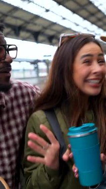 Ayrılmadan önce tren istasyonunda selfie çeken mutlu arkadaşlar, yeniden kullanılabilir kupalarının keyfini çıkarıyorlar.