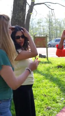 Dört kadın neşeyle dans ediyor ve parkta arkadaşlıklarını kutluyorlar. Birlikte mutlu anılar yaratıyorlar.