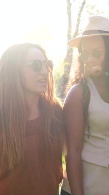 Farklı geçmişlere sahip, sıcak güneş ışığının tadını çıkaran, şık güneş gözlüğü takan ve hafta sonu dışarıda kaygısız vakit geçirirken gerçek kahkahalar atan kadın arkadaşlar.