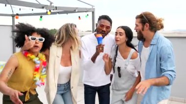 Arkadaşlar şehrin çatısında karaoke yapıyor, enerjik müzik eşliğinde canlı yaz toplantılarının ve çeşitli genç yetişkinler arasında neşeli bir bağ kurulmasının keyfini çıkarıyorlar.