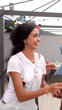 Çatıdaki bir partide dans eden mutlu çoklu etnik arkadaşlar müzik, içki ve yaz atmosferinin tadını çıkarıyorlar.