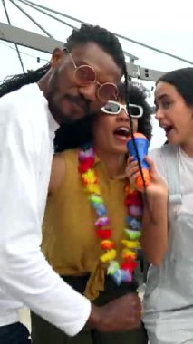 Çeşitli çok kültürlü arkadaşlar enerjik bir karaoke performansı sergiliyorlar. Yaz kutlamalarında coşkulu bir şekilde şarkı söylüyorlar. Neşeli bir bağ ve kaygısız bir ruhla.