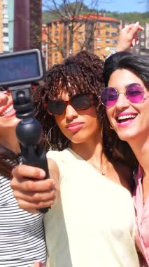 Neşeli şehir maceralarını paylaşan kadın arkadaşlar, hafta sonu kaçamakları sırasında güneşli şehir manzarası ile unutulmaz anlar kaydediyorlar.