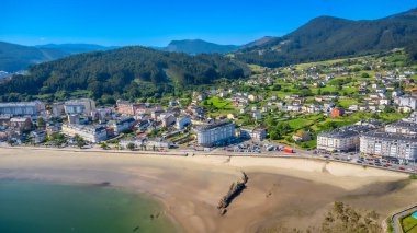 Kıyı şeridi boyunca uzanan Covas kumsalının dingin güzelliğini gözler önüne seren nefes kesici hava manzarası, yemyeşil yemyeşil yerleşmiş pitoresk bir kasaba.