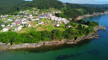 Covas sahilinin ve Viveiro, Lugo, Galicia, İspanya 'nın çevresindeki köyün havadan görünüşü kıyı şeridini ve yemyeşil bitkileri gösteriyor.
