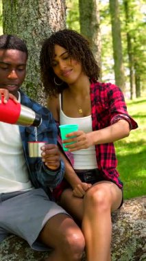 Genç yürüyüşçüler ormanda mola veriyor, bir içki dolduruyor ve bir an olsun dinleniyorlar.