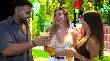 Arkadaşlar canlı bir gece etkinliğinde toplanır, neşeli anlar ve kokteylleri paylaşarak neşeli enerji ve arkadaşlıkla kutlarlar.