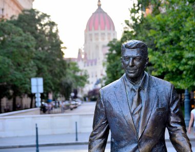 Eski ABD Başkanı Ronald Reagan 'ın bronz heykeli, uzaktaki Macar parlamento binası ile Budapeşte, Hungary' deki Szabadsag 'a gelen ziyaretçileri karşıladı.