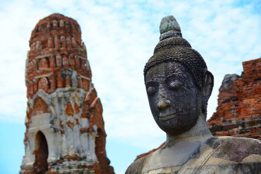 Serene Buddha heykeli antik tapınak kalıntılarının arasında ayakta duruyor, Ayutthaya 'nın tarihsel mirasının ruhsal özünü yakalıyor.