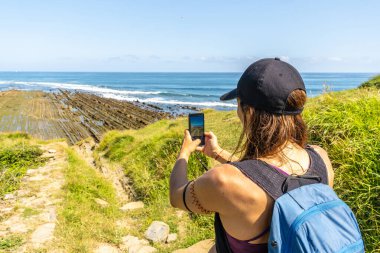 Zumaia, Bask Bölgesi, İspanya 'daki Sakoneta Sahili' ndeki etkileyici uçurumların fotoğraflarını çeken yürüyüşçü eşsiz bir jeolojik oluşum.
