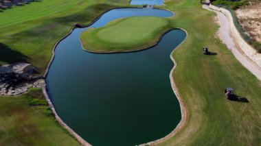 Pahalı göl kenarındaki golf arabalarıyla lüks golf sahası, dingin yaz eğlencesi aktiviteleri ve el değmemiş yeşil arazi.