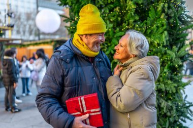 Yaşlı bir adam kış tatilinde yılbaşı hediyesiyle karısına sürpriz yapıyor.