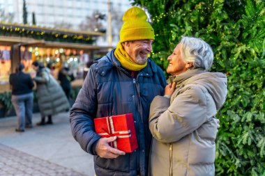 Yılbaşı hediyelerini açık hava pazarında değiş tokuş eden, Noel ruhunun tadını çıkaran son sınıf çifti.