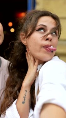 İki neşeli genç kadın birlikte gülüyor ve birbirlerine bağlanıp eğleniyorlar.