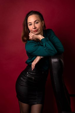 Stylish young woman posing near the armchair. Business photo session of a woman.