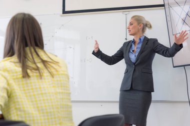 Sınıfta ders veren kadın öğretmen ya da profesör.