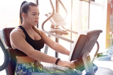 Beautiful sportswoman exercising and training at fitness club