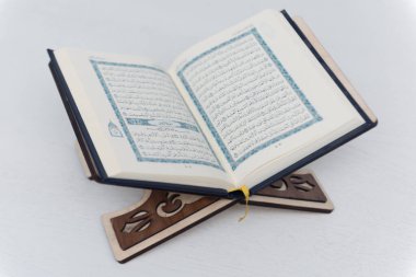 The words on Qoran is arabic words which means the Holy Qoran. Muslim beads and Koran on wooden table. Islamic concept.