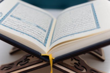 The words on Qoran is arabic words which means the Holy Qoran. Muslim beads and Koran on wooden table. Islamic concept.