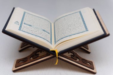 The words on Qoran is arabic words which means the Holy Qoran. Muslim beads and Koran on wooden table. Islamic concept.