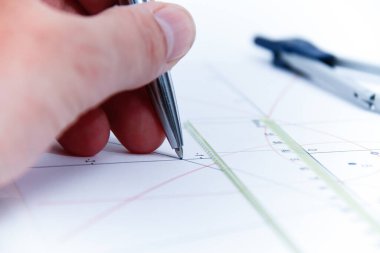 Professional architect working at his desk, measuring and estimating the building project