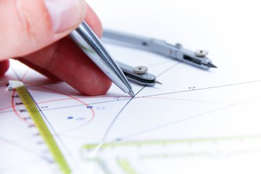 Professional architect working at his desk, measuring and estimating the building project