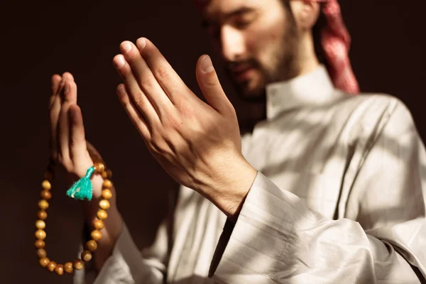 Hand of male muslim praying with mosque interior background during ramadan