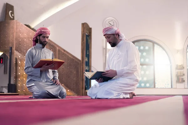ラマダーンの日のクルアーンを読みなさい 2人の若いイスラム教徒の男性がモスクで一緒にクルアーンを読む — ストック写真
