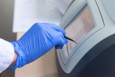 Modern genetik laboratuvarında test analizi için mikro pipeti kullanan bir araştırmacı.