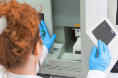 Modern genetik laboratuvarında test analizi için mikro pipeti kullanan bir araştırmacı.