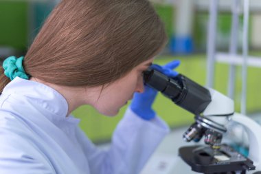 Modern genetik laboratuvarında test analizi için mikro pipeti kullanan bir araştırmacı.
