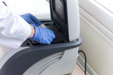 Modern genetik laboratuvarında test analizi için mikro pipeti kullanan bir araştırmacı.