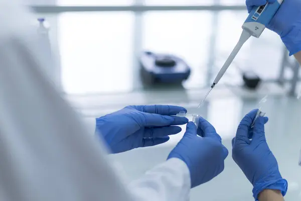 Research scientist using micro pipette for test analysis in modern genetic laboratory