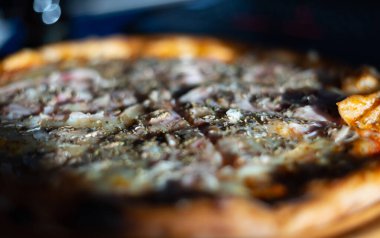 Tahta masada servis edilen İtalyan karışık pizzasına yakın çekim