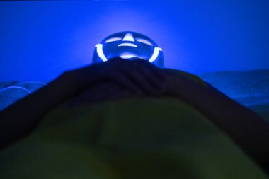 Kadının yüzündeki Fotodinamik Tedavi yüz maskesi