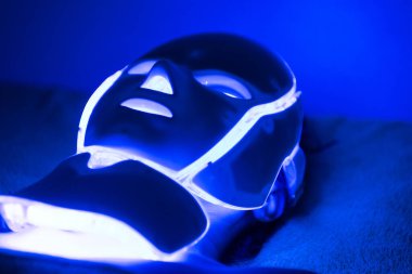 Kadının yüzündeki Fotodinamik Tedavi yüz maskesi