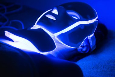 Kadının yüzündeki Fotodinamik Tedavi yüz maskesi