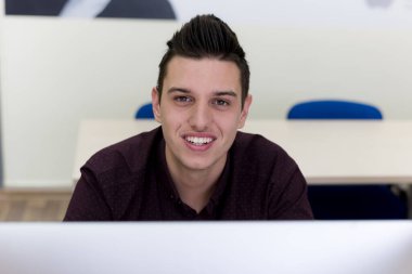 Sınıftaki neşeli erkek bilişim öğrencisi.