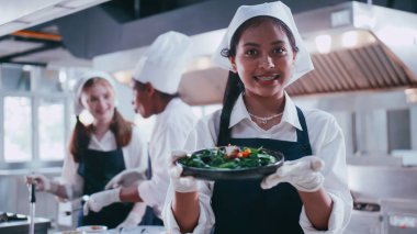 Bir grup kız öğrenci yemek yapmayı öğrenirken eğleniyor. Aşçılık sınıfındaki kız öğrenciler..